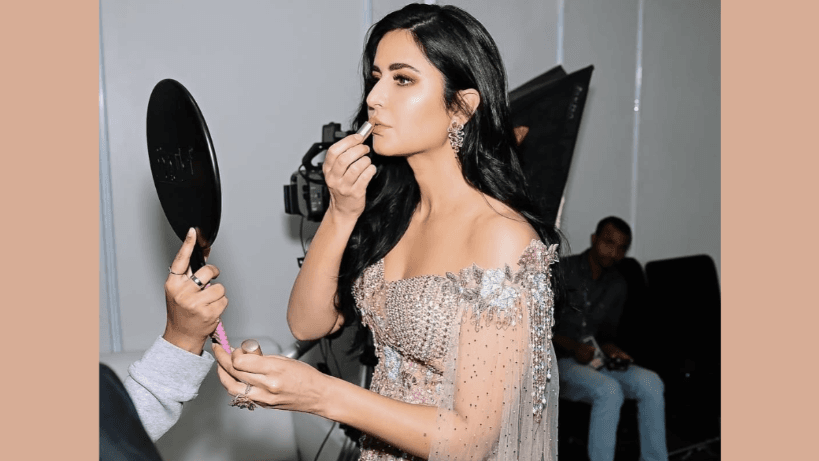 Actor Katrina Kaif gets ready backstage during a brand campaign shoot, seen applying lip color as part of her glam routine.